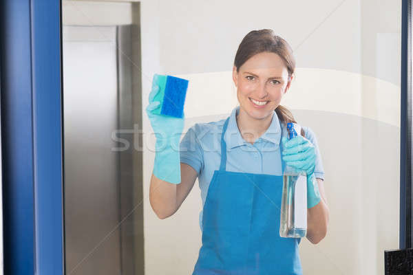 Female Janitor Cleaning Glass Stock photo © AndreyPopov