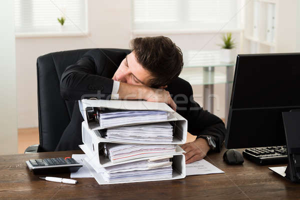 Businessman Sleeping On Binders Stock photo © AndreyPopov