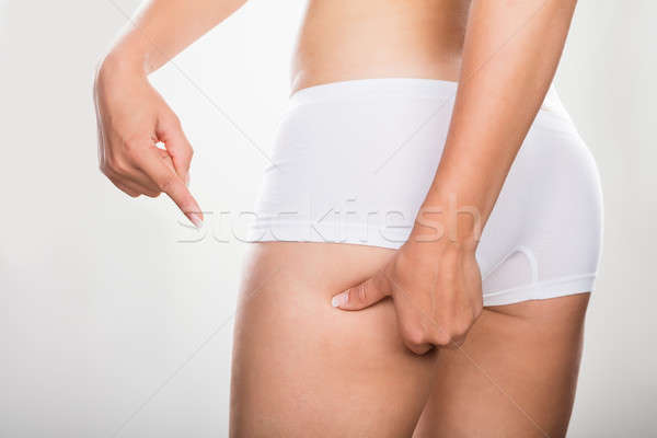 Woman Pinching Excessive Fat Of Buttock Stock photo © AndreyPopov