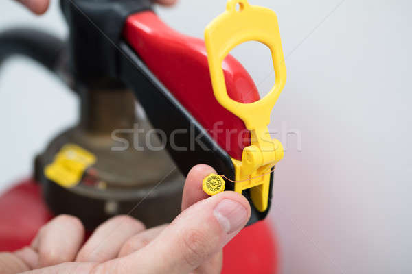 Technician's Hand Pointing To Symbol On Red Fire Extinguisher Stock photo © AndreyPopov