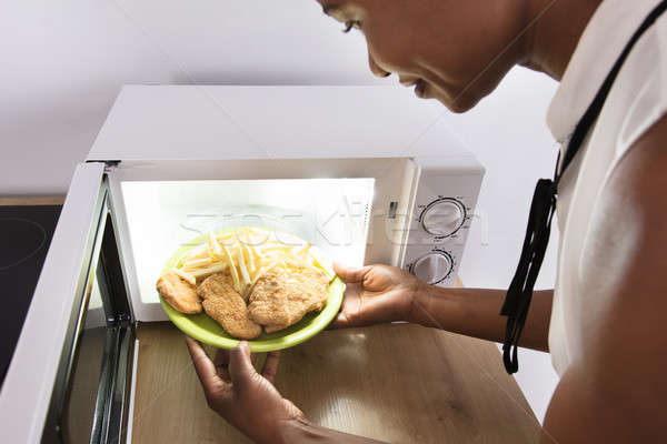 Persona riscaldamento alimentare forno a microonde forno Foto d'archivio © AndreyPopov