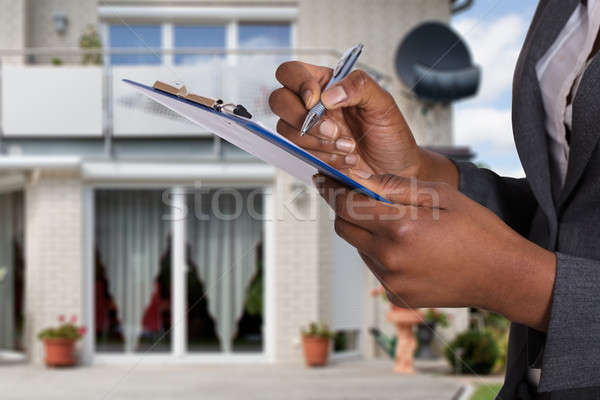 Person Filling Document In Front Of House Stock photo © AndreyPopov