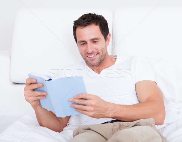 Portrait jeune homme lecture livre lit [[stock_photo]] © AndreyPopov