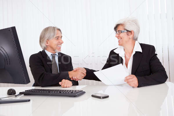 Altos socios reunión de negocios sonriendo sesión junto Foto stock © AndreyPopov