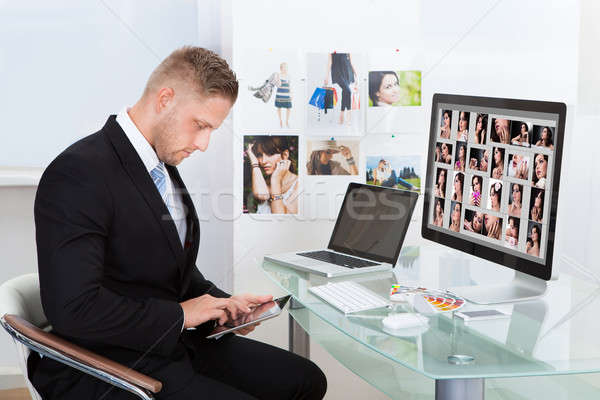 Businessman editing photographs Stock photo © AndreyPopov