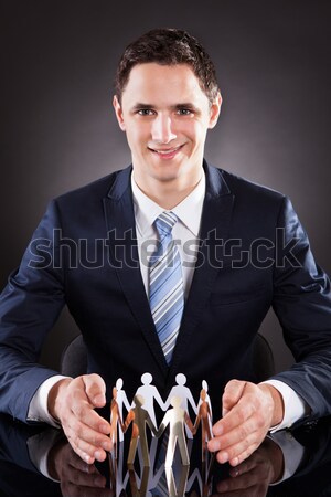 Smiling Businessman Joining Puzzle Pieces At Desk Stock photo © AndreyPopov