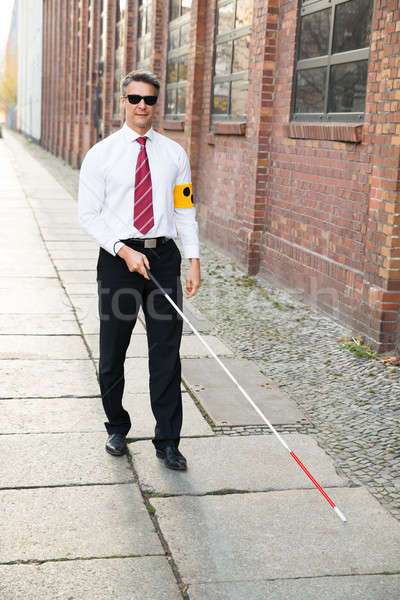 Blind Man Walking On Sidewalk Holding Stick Stock photo © AndreyPopov