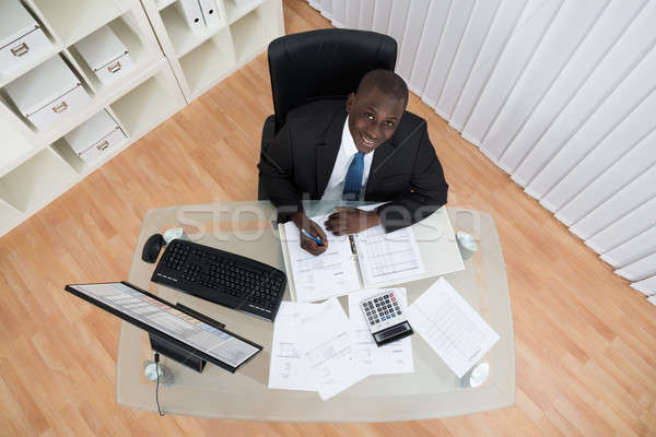 Stock photo: Businessman Calculating Bills In Office