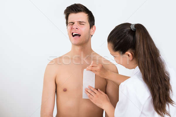 Beautician Waxing Man's Chest In Beauty Center Stock photo © AndreyPopov