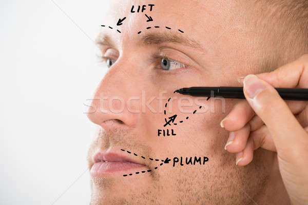 Man's Face With Correction Line Drawn By Person's Hand Stock photo © AndreyPopov