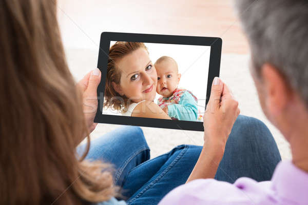 Stock photo: Couple Looking At Photo On Digital Tablet