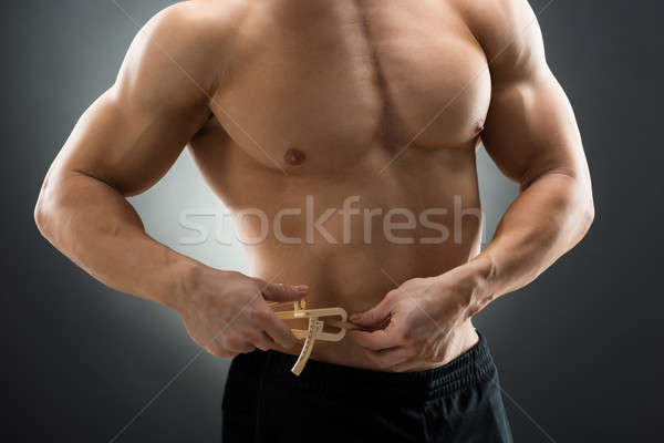 Muscular Man Measuring Fats With Caliper Stock photo © AndreyPopov