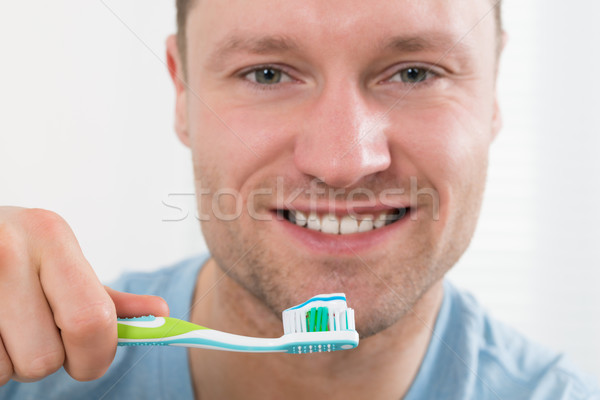 Happy Man Brushing Teeth Against White Background Stock photo © AndreyPopov