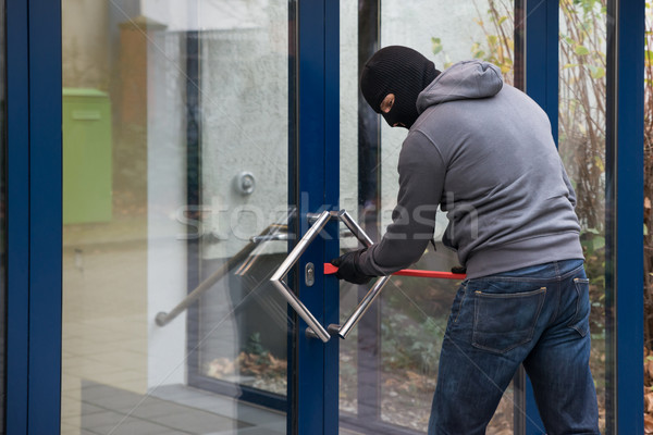 Man Using Crowbar To Open Glass Door Stock photo © AndreyPopov
