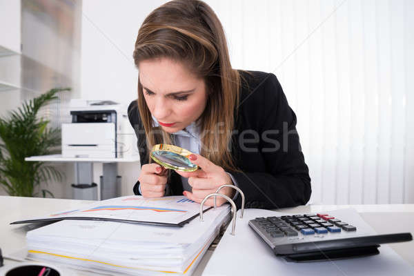 Mujer de negocios examinar factura lupa jóvenes escritorio Foto stock © AndreyPopov