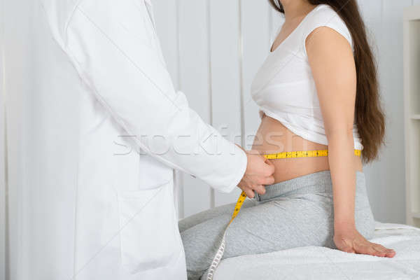 Doctor Checking Growth Of Baby In Clinic Stock photo © AndreyPopov
