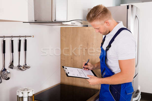Young Repairman Checking Kitchen Extractor Filter Stock photo © AndreyPopov