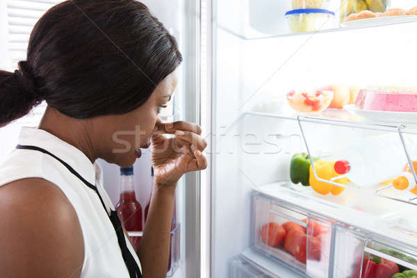 Mulher nariz comida geladeira Foto stock © AndreyPopov