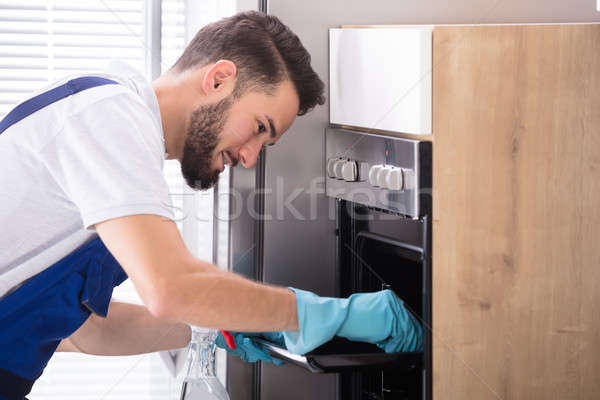 Limpieza horno cocina feliz masculina Foto stock © AndreyPopov