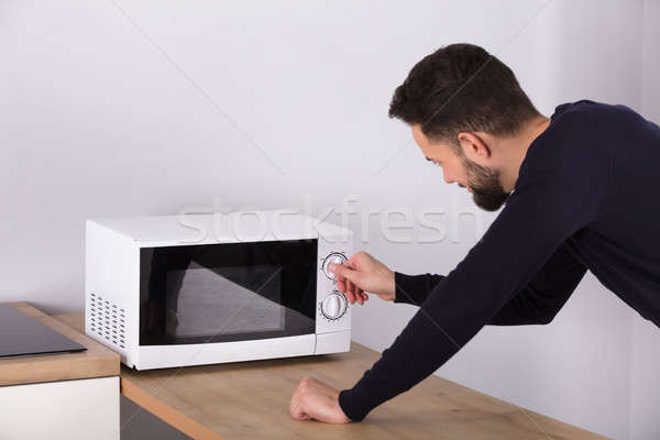 Man Preparing Food In Microwave Oven Stock photo © AndreyPopov