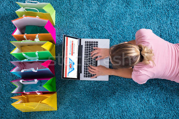 женщину сидят ковер торговых онлайн используя ноутбук Сток-фото © AndreyPopov