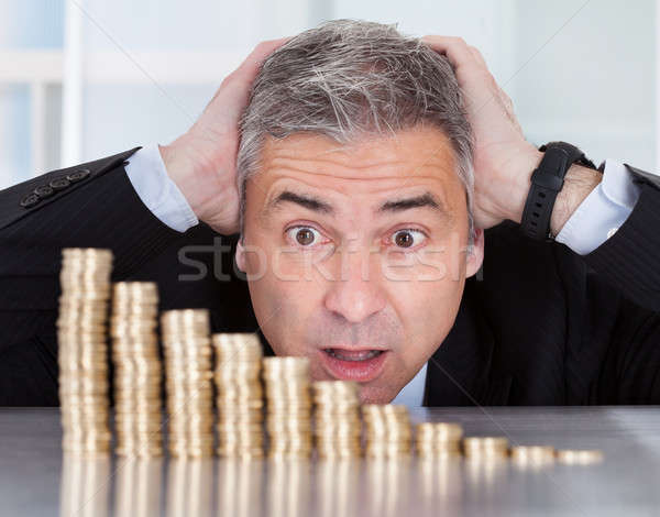 Surprised Businessman With Stack Of Coins Stock photo © AndreyPopov