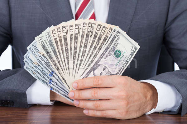 üzletember tart bankjegyek asztal üzlet pénz Stock fotó © AndreyPopov