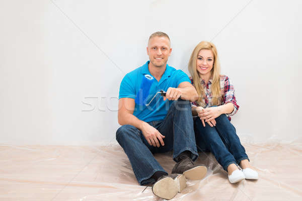 Happy Couple In Front Of Partially Painted Wall Stock photo © AndreyPopov