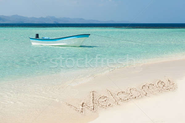 Boat Moored On Sea With Welcome Text Drawn On Sand Stock photo © AndreyPopov