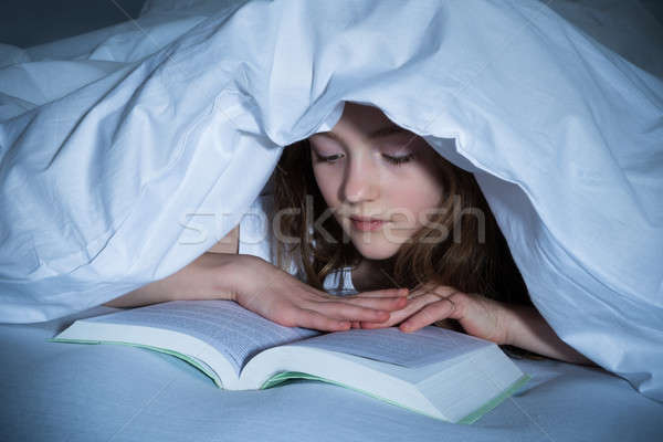 Girl Reading Book In Bedroom Stock photo © AndreyPopov