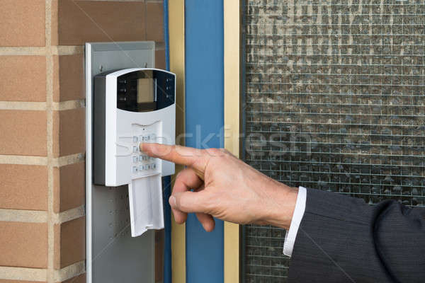 Stock photo: Close-up Of Businessperson Entering Code In Security System