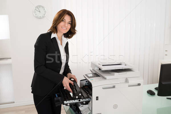 Businesswoman Fixing Copy Machine Stock photo © AndreyPopov