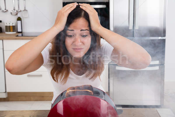 Frustrated Woman Looking At Burnt Toast In Toaster Stock photo © AndreyPopov