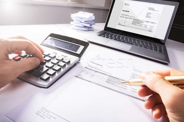 Businessperson's Hand Calculating Invoice Stock photo © AndreyPopov