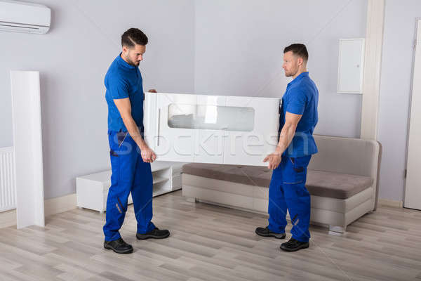Two Movers Holding Furniture In Living Room Stock photo © AndreyPopov