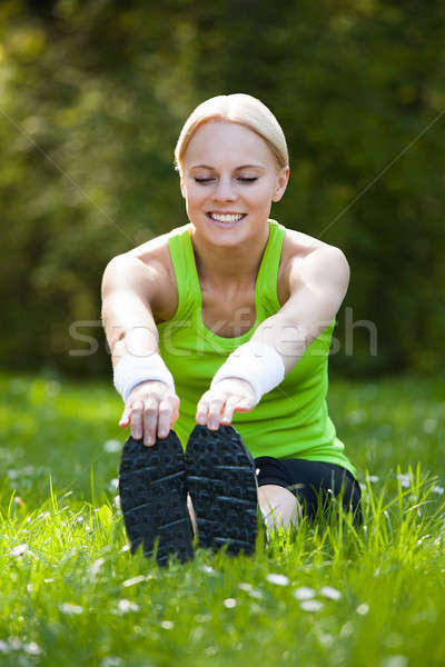 Stock photo: Young Happy Blonde Woman Stretching Leg