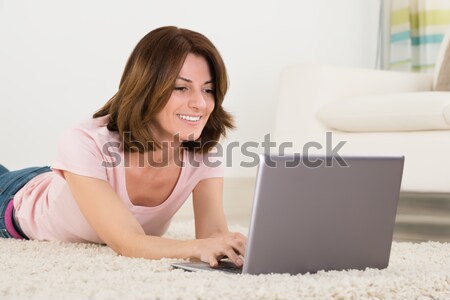 Woman relaxing on sofa using laptop Stock photo © AndreyPopov