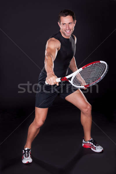 [[stock_photo]]: Jeune · homme · raquette · de · tennis · isolé · noir · sourire