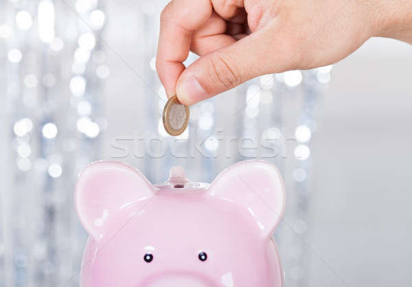 Man Inserting Coin In Piggybank Stock photo © AndreyPopov