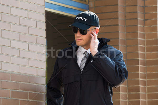 Jóvenes guardia de seguridad pie entrada primer plano escuchar Foto stock © AndreyPopov