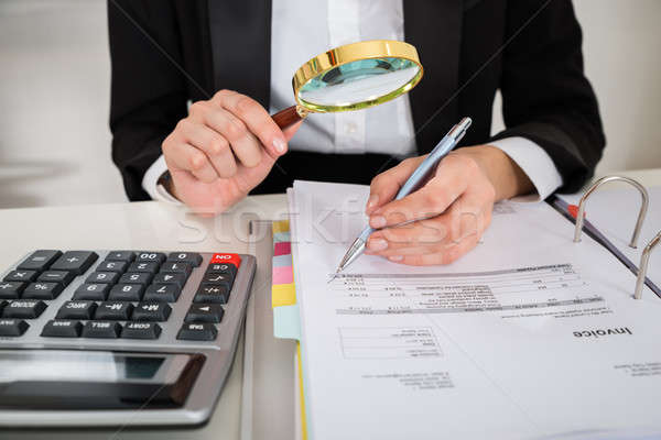 Vrouwelijke revisor factuur boekhouder vergrootglas bureau Stockfoto © AndreyPopov