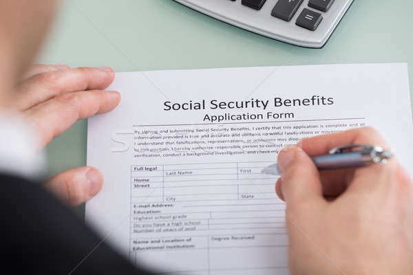 Person Hand Filling Social Security Benefits Form Stock photo © AndreyPopov