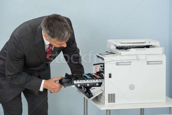 Businessman Fixing Cartridge In Printer Machine At Office Stock photo © AndreyPopov