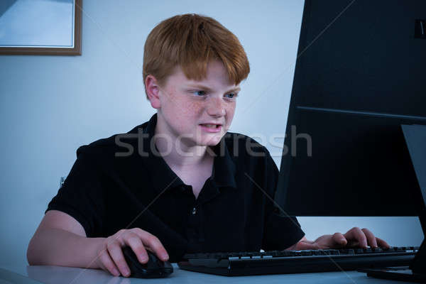 Angry Boy Working On Computer Stock photo © AndreyPopov