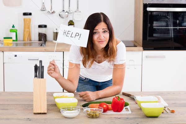 Woman Holding Help Flag In Kitchen Stock photo © AndreyPopov