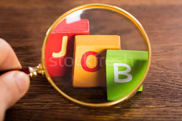 Person Holding Magnifying Glass Over The Word Job Stock photo © AndreyPopov
