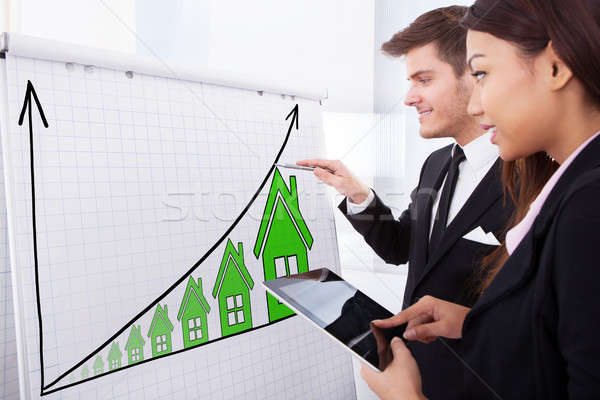 Two Businesspeople With House Raise Concept On Flipchart Stock photo © AndreyPopov