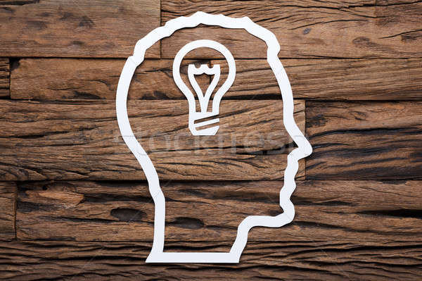 Paper Businessman's Head Outline With Light Bulb On Wooden Table Stock photo © AndreyPopov
