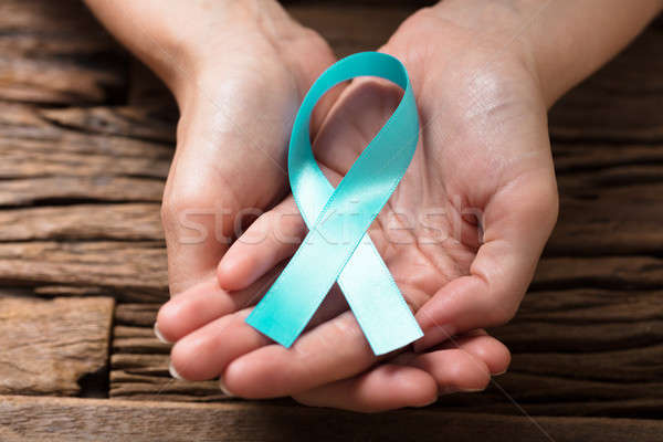 Human Hand Showing Teal Ribbon To Support Breast Cancer Cause Stock photo © AndreyPopov