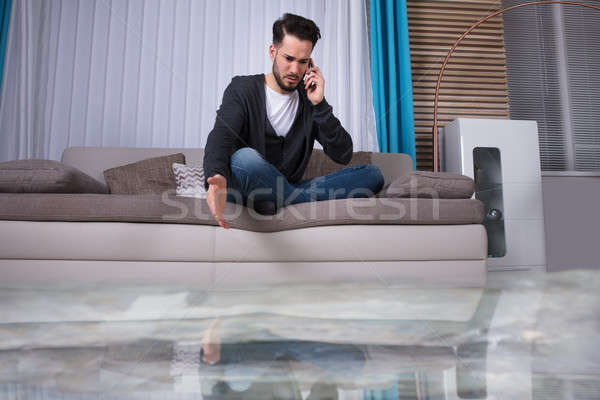 Férfi ül kanapé hív vízvezetékszerelő padló Stock fotó © AndreyPopov